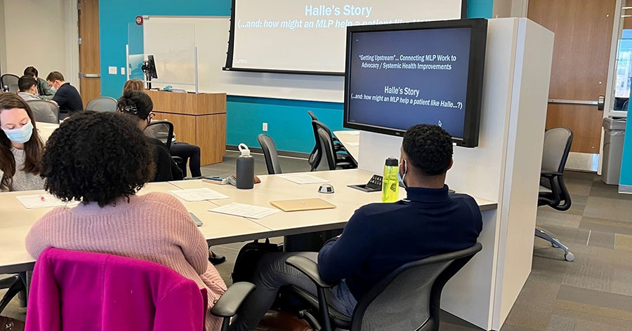 Students viewing webinar on display screen